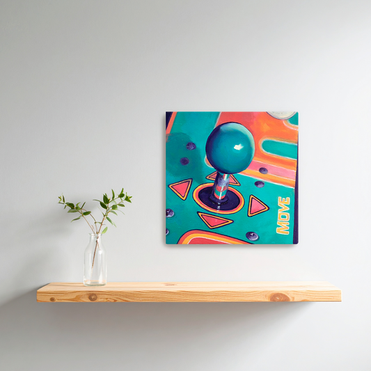 Colorful arcade joystick painting on a white wall above a wooden shelf with a vase of green leaves.