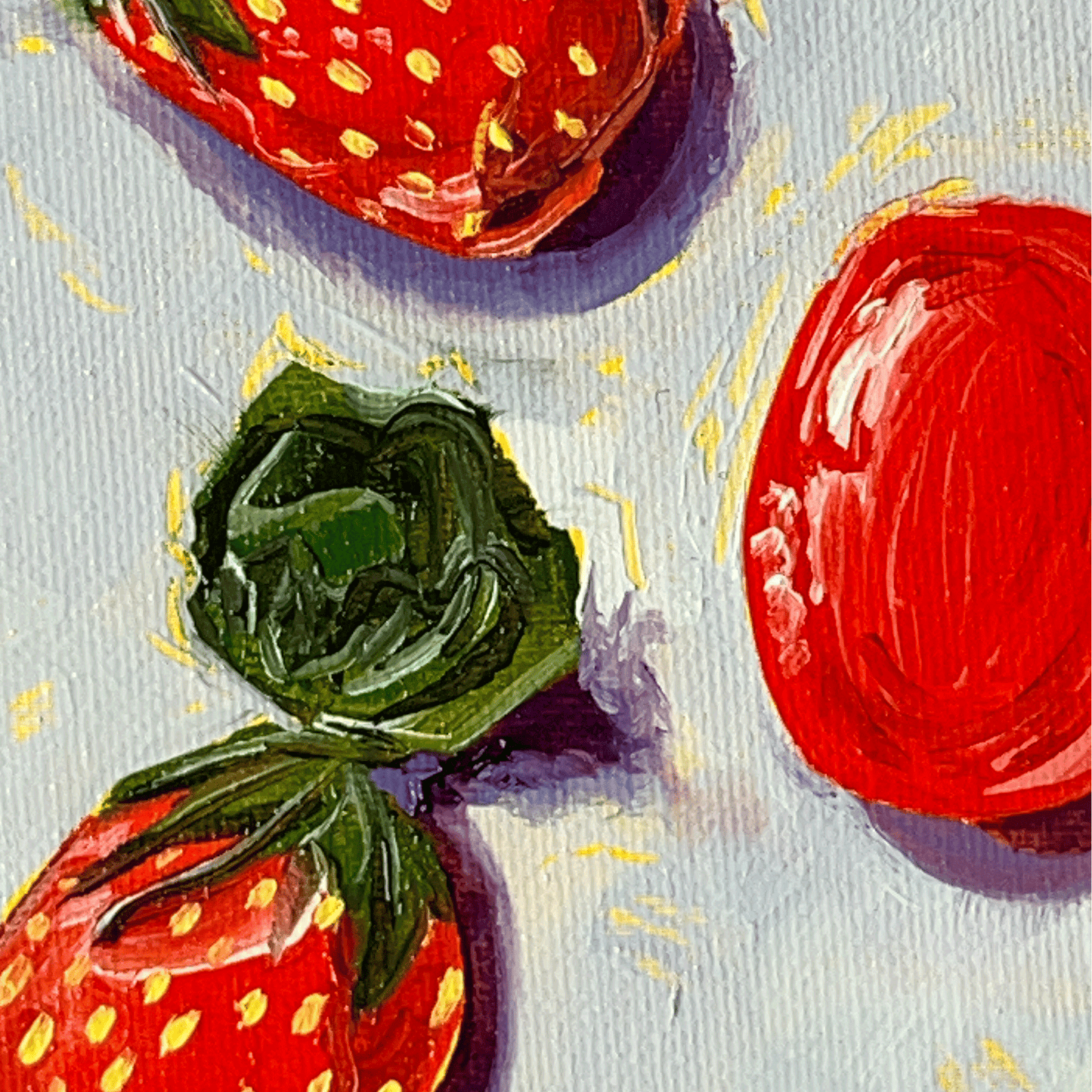 Close-up of painted strawberry candies with shiny wrappers on a textured surface.