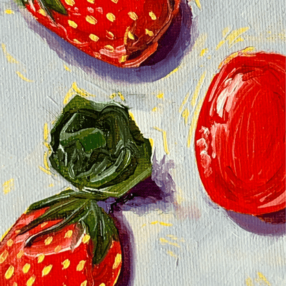 Close-up of painted strawberry candies with shiny wrappers on a textured surface.